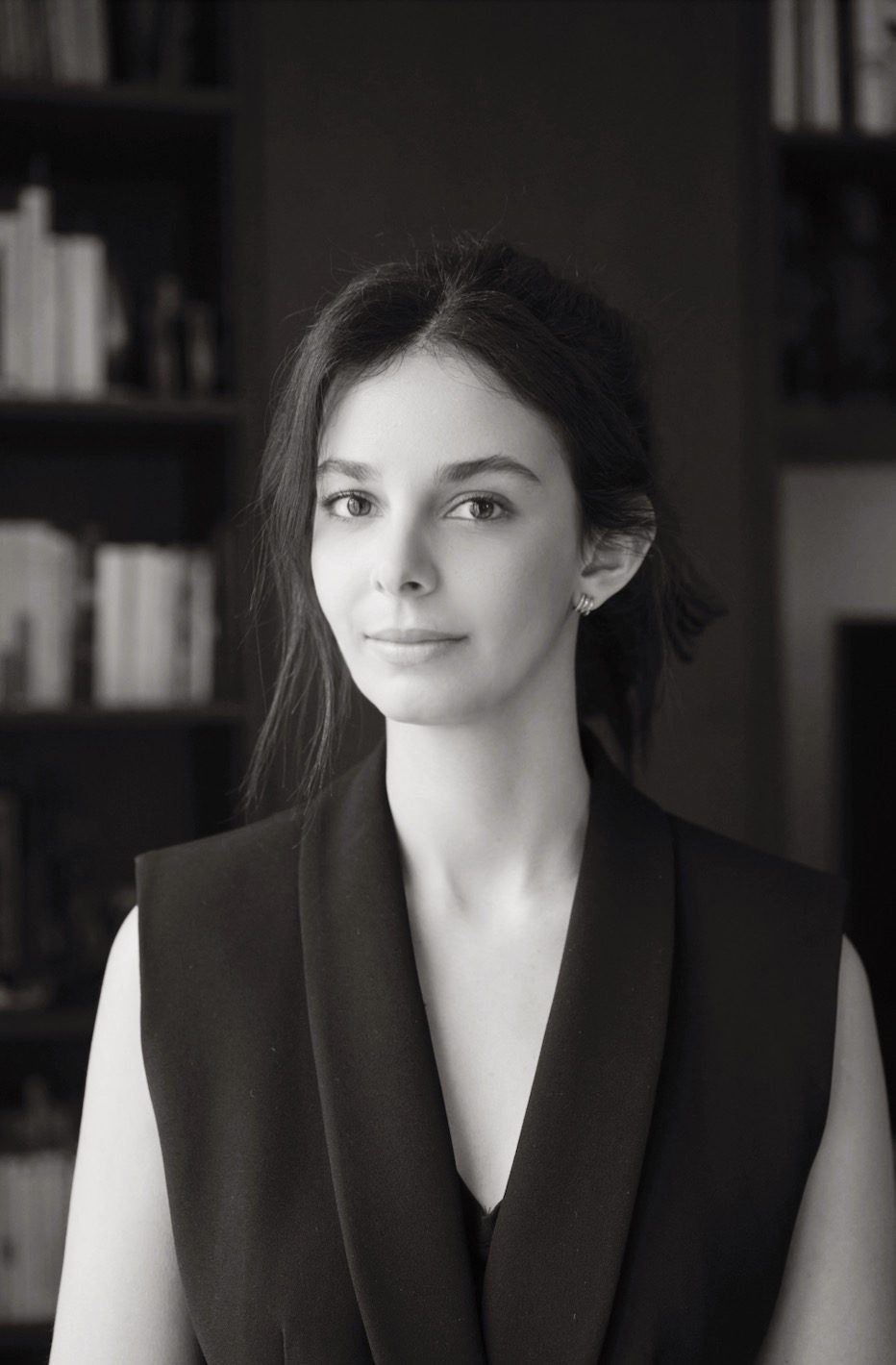 Portrait en noir et blanc devant une bibliothèque