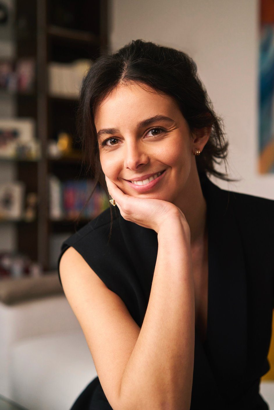 Yasmin souriante, main sous le menton, veste noire